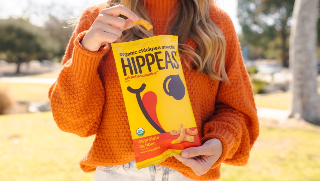 A female holding a bag of Hippeas