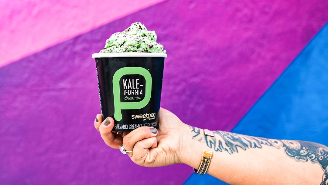 Hand holding pint of April Fool's Day flavor Kale-ifornia Dreaming.