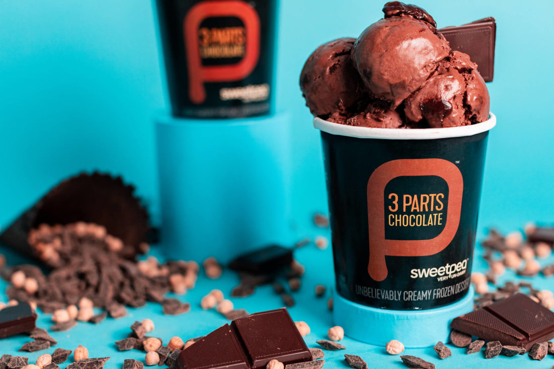 Two pints of SweetPea plant-based chickpea ice cream flavor 3 Parts Chocolate against a teal blue background