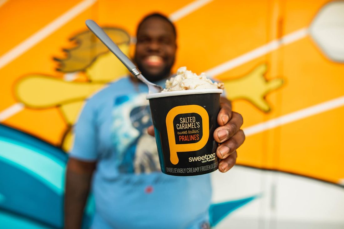 Man holding a pint of SweetPea plant-based ice cream in salted Caramel's sweet talkin' pralines