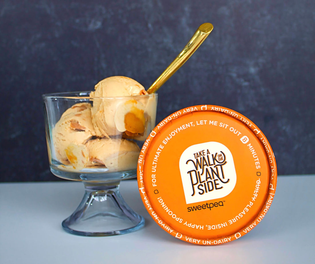 Glass cup filled with big scoops of sweetpea plant-based ice cream flavor peanut butter bomb